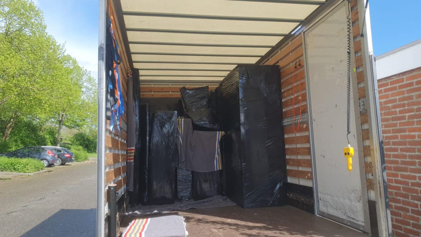 Ingepakte meubels op laadklep van verhuiswagen